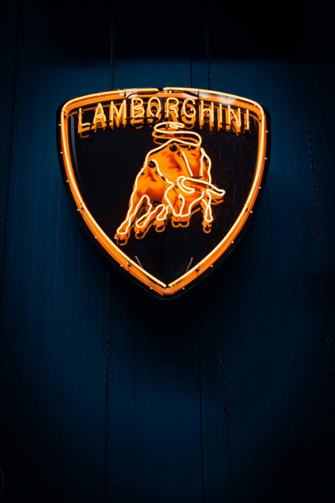 A vibrant neon Lamborghini logo glowing in the night in İzmir, Türkiye, exuding luxury and elegance.